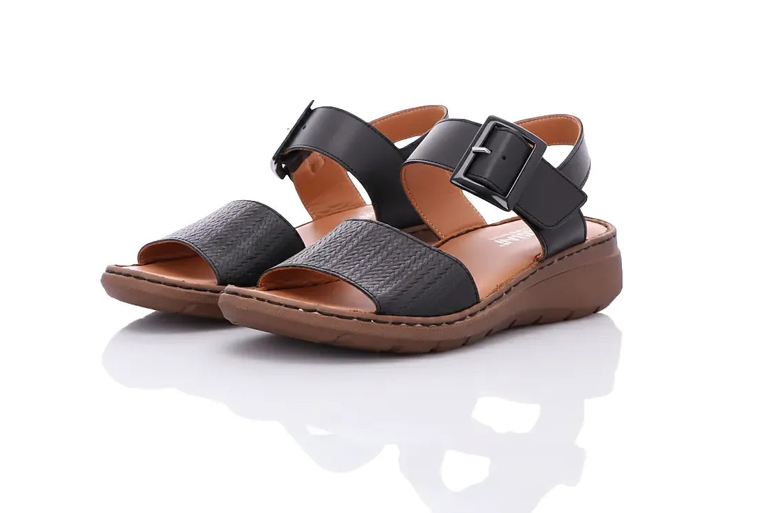Sandalen in schwarz vor weißem Hintergrund