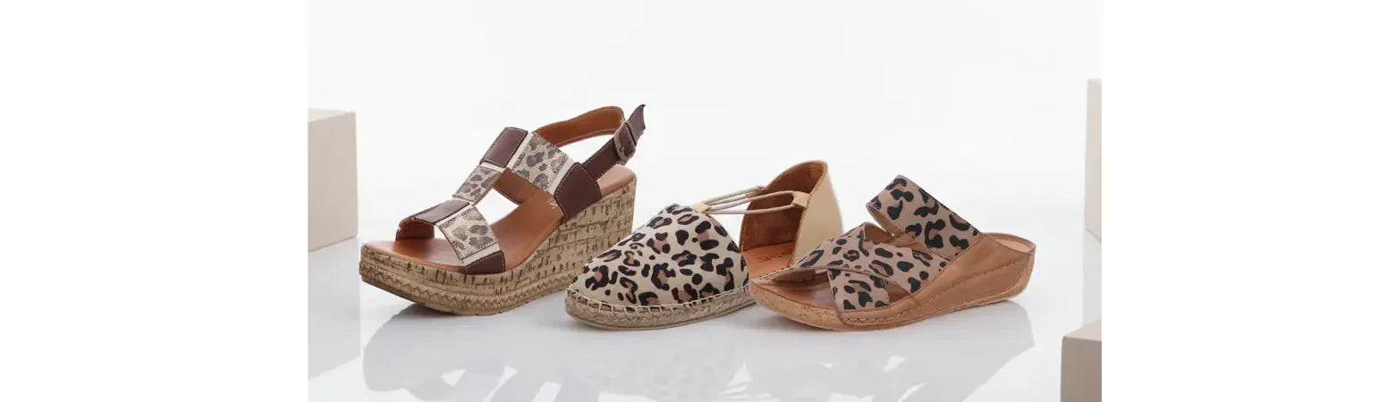Leo-Print Damenschuhe, weißer Hintergrund, drei Schuhe im Leo Print stehen auf dem Boden und spiegeln sich