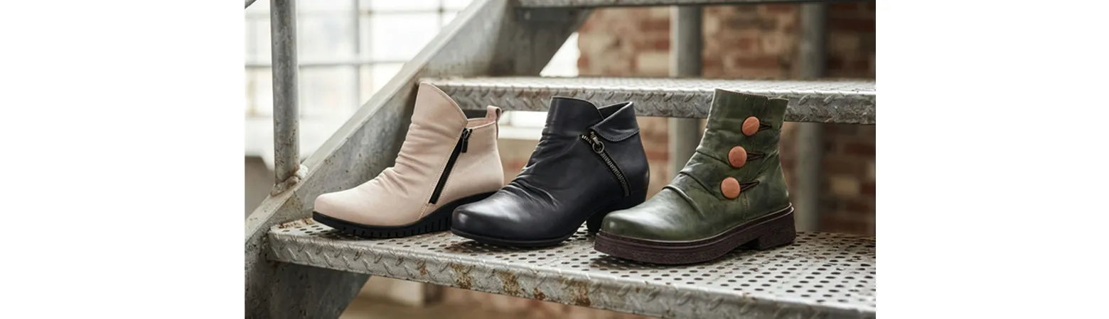 Herbst- & Winterschuhe drei unterschiedliche Boots stehen auf einem Pflasterweg